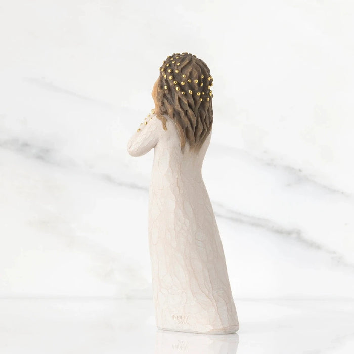 A figurine of a woman elegantly dressed in a flowing white gown, showcasing intricate details and graceful posture.