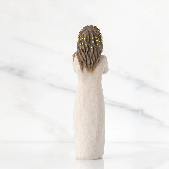 A decorative figurine depicting a woman in a white dress, highlighting her poised stance and delicate features.
