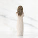 A decorative figurine depicting a woman in a white dress, highlighting her poised stance and delicate features.