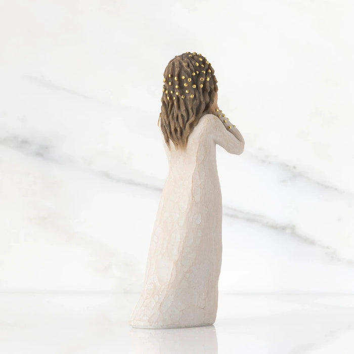 A charming figurine of a woman wearing a white dress, capturing her elegance and the fine craftsmanship of the piece.