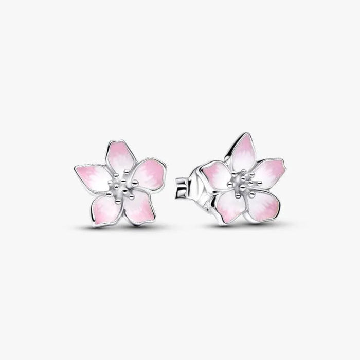 Silver earring with a pink flower-shaped charm on a white background