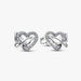Silver earring with a heart and butterfly shaped charm on a white background