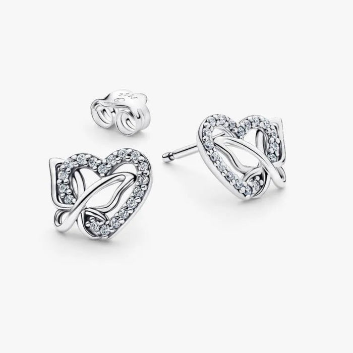Silver earring with a heart and butterfly shaped charm on a white background