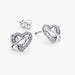 Silver earring with a heart and butterfly shaped charm on a white background