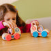 Three colorful wooden toys, each displaying a child's face, designed to engage and delight young children.