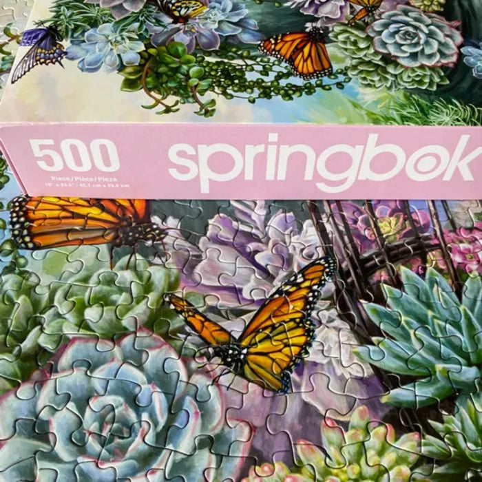 Springbok 500 piece puzzle with succulents and butterflies on a pink border