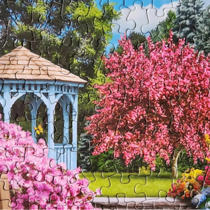 Jigsaw puzzle with a garden scene featuring a gazebo and pink flowers.