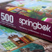 Springbok 500 piece puzzle box with colorful puzzle pieces in the foreground