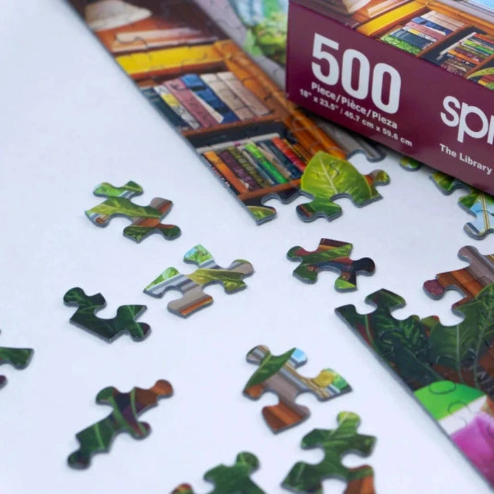 Jigsaw puzzle with pieces scattered on a surface, featuring a 'The Library' theme.