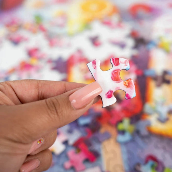 Hand holding a colorful puzzle piece with a blurred puzzle in the background
