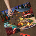 Puzzle with a scenic design of a cabin and truck, with a hand placing a piece on it.