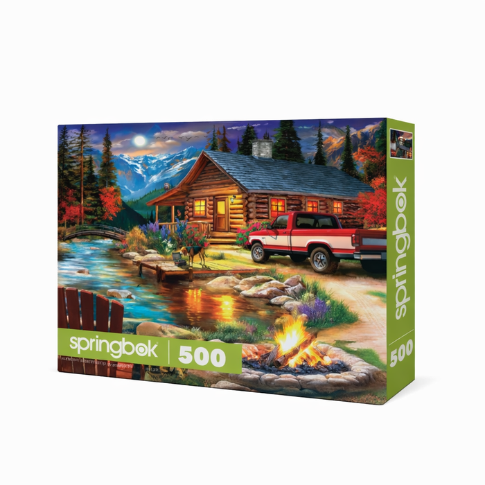 Jigsaw puzzle box featuring a cabin scene with a truck, fire pit, and mountains.