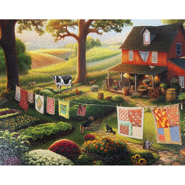 Scenic farm with a barn, garden, and clothesline with quilts.