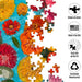 The Springbok Floating Flowers 1000 Piece Jigsaw Puzzle features vibrant, delicate flowers drifting across a serene background.
