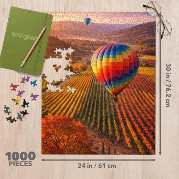 This Springbok Vineyard Balloon 1000-Piece Jigsaw Puzzle captures a beautiful vineyard scene with a colorful hot air balloon floating above the landscape.