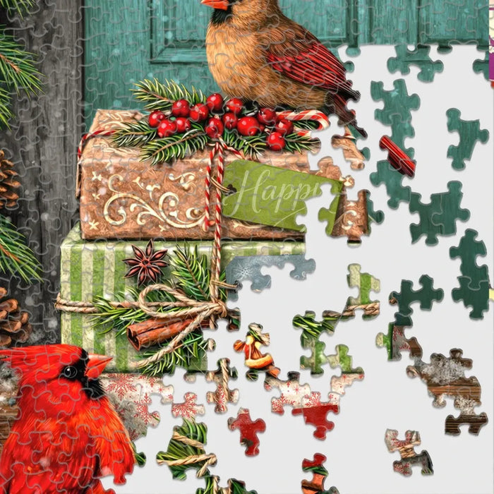 This Springbok Cardinal Couriers 500 Piece Jigsaw Puzzle features a fleet of bright red cardinal birds delivering mail across a snowy winter scene. 