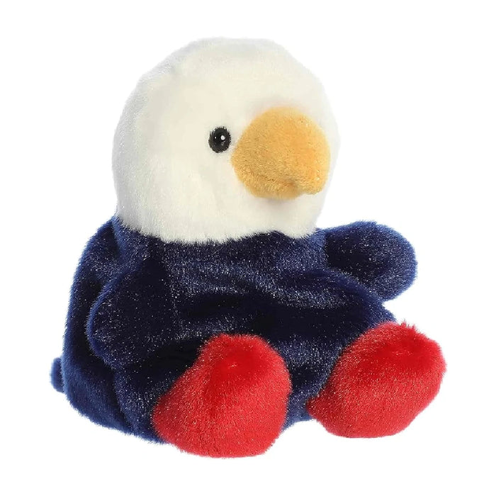 A stuffed bald eagle perched on a white background, featuring realistic details and a soft texture.