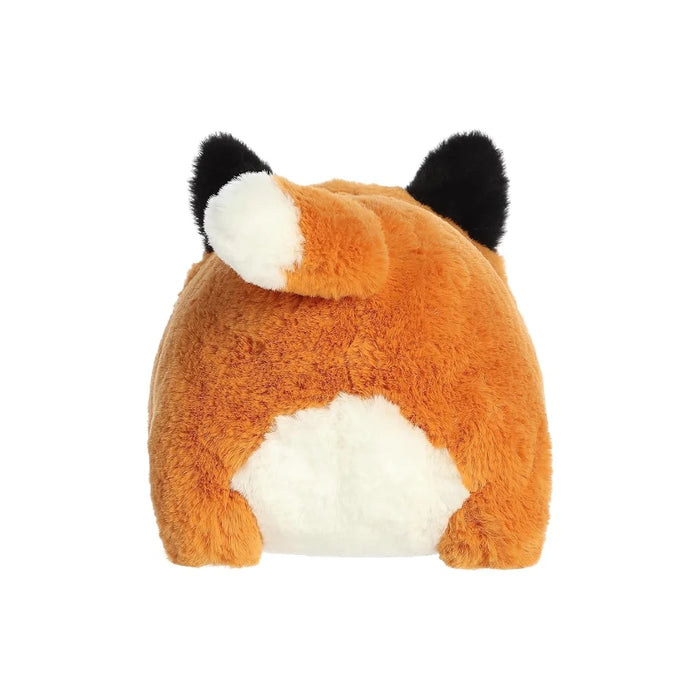 A side view of a stuffed animal fox, with its fluffy tail curled and eyes closed.