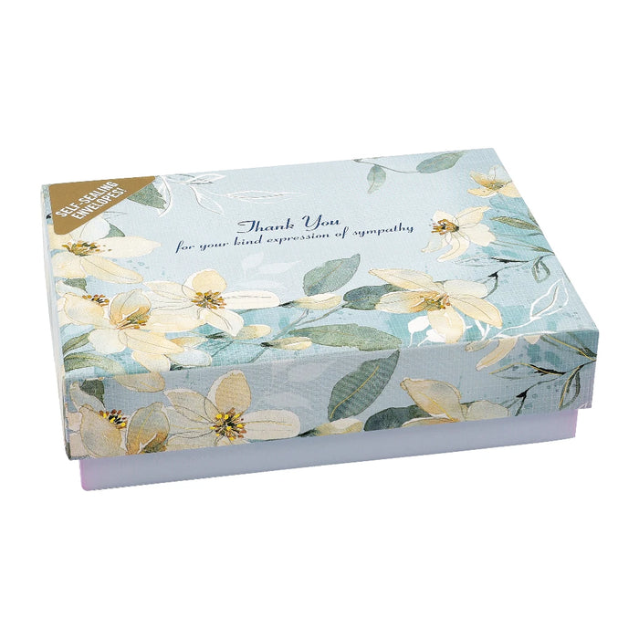A thank you card and envelope adorned with colorful flowers, resting on a light surface.
