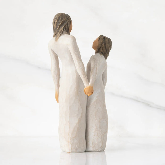 Two figurines holding hands on a white background