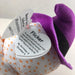 Purple ghost toy with a tag named 'Flicker' on a white background