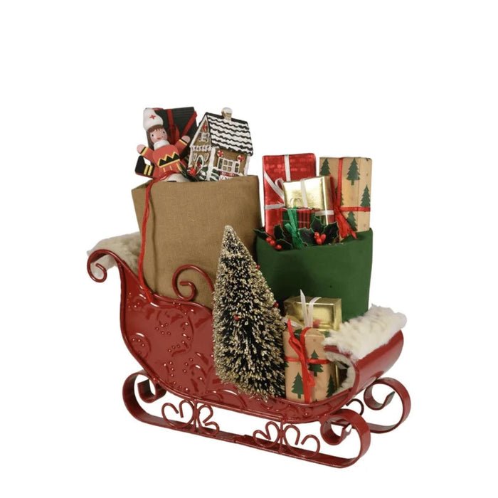 Decorative Byer's Choice Christmas sleigh with various festive items on a white background