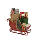Decorative Byer's Choice Christmas sleigh with various festive items on a white background