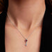 Close-up of a woman wearing the Pandora Elevated Heart Key Collier Necklace with a heart-shaped key pendant and red crystal.