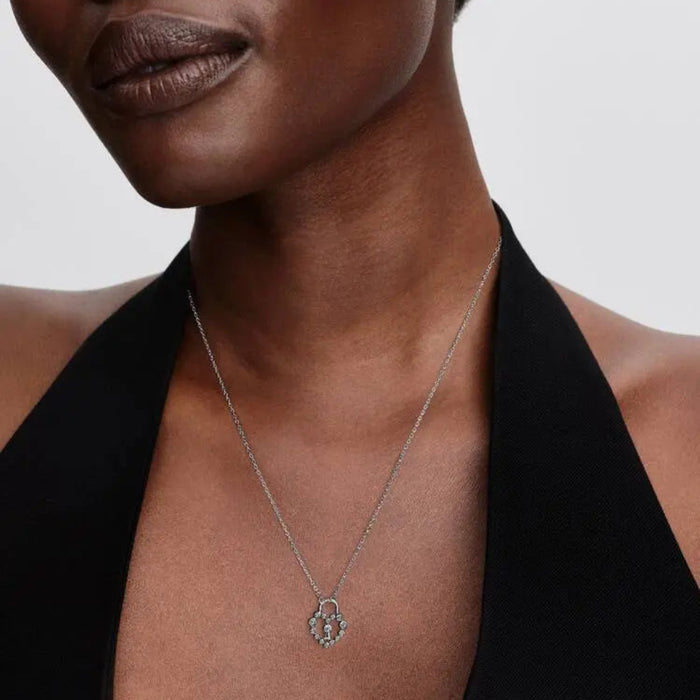 Woman wearing the Pandora Sparkling Heart Padlock Pendant Necklace in sterling silver, featuring sparkling cubic zirconia forming a heart around a central padlock.
