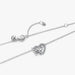 Silver necklace with a heart and butterfly shaped charm on a white background