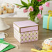 Medium pink‑and‑cream gift box with gold accents displayed on a table