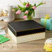Large white gift box with gold diamond designs and black lid displayed on a party table 