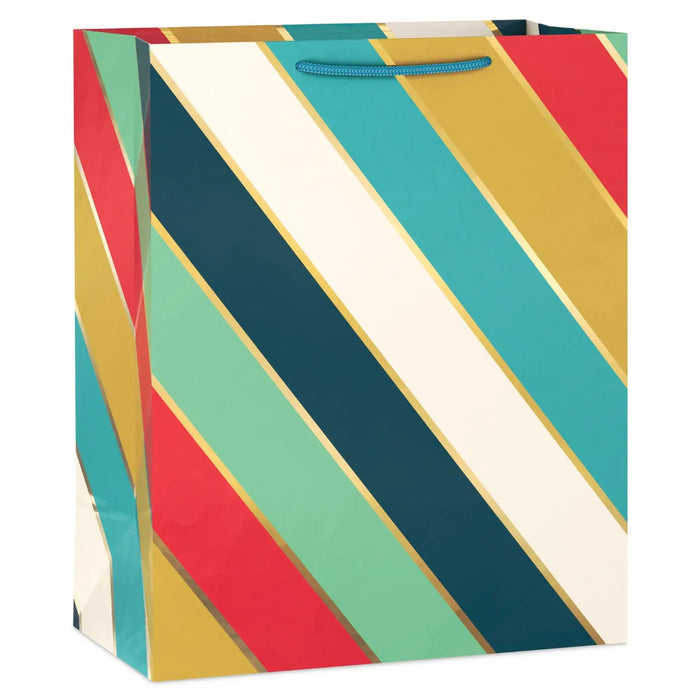 Large gift bag with diagonal stripes in mint, navy, cream, turquoise, mustard yellow, and orange‑red, accented with metallic gold bands and herringbone ribbon handles
