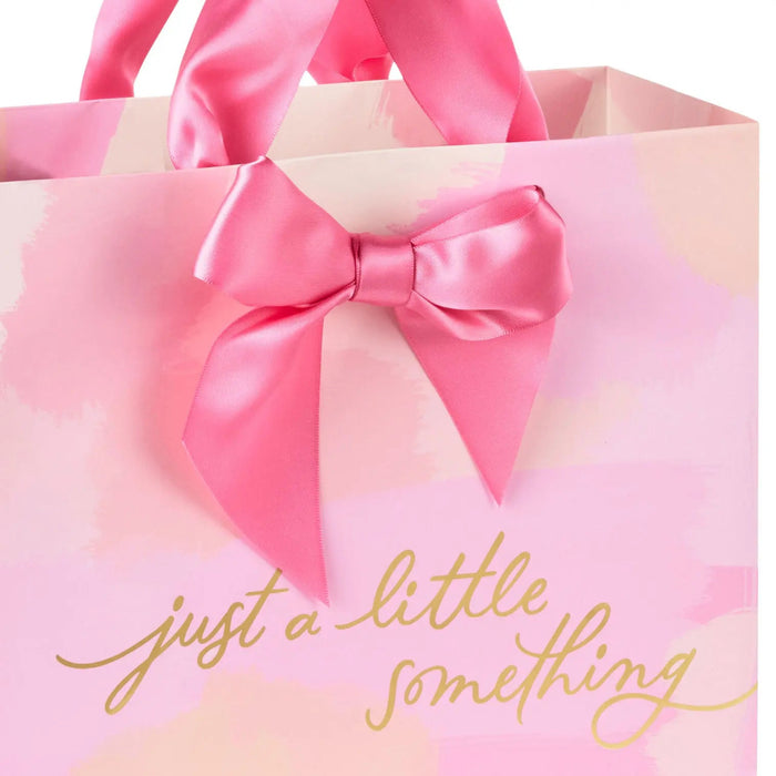 Close‑up of pink and peach gift bag with gold‑foil script