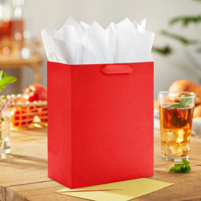 Hallmark 9.6-inch solid red medium gift bag with a classic matte finish, sturdy handles, and a versatile design for birthdays, holidays, and special occasions.