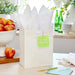 Green “Welcome Little One” gift tag with gold foil stars displayed on a gift bag