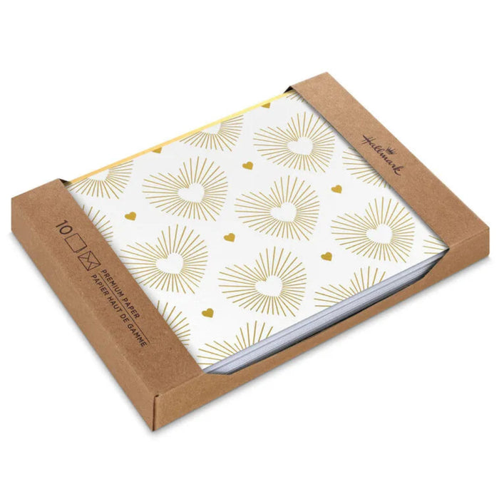 Packaged paper products with gold sunburst pattern on a white background