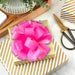Large fuchsia gift bow with wide ribbon loops displayed on a gift