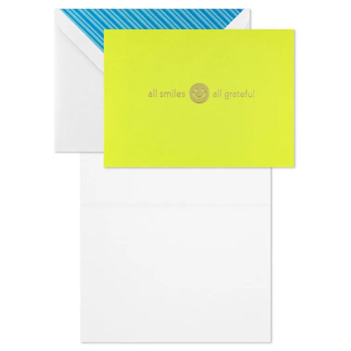 Lime green card with 'all smiles all grateful' text and smiley face, on a white card with blue and white striped envelope.