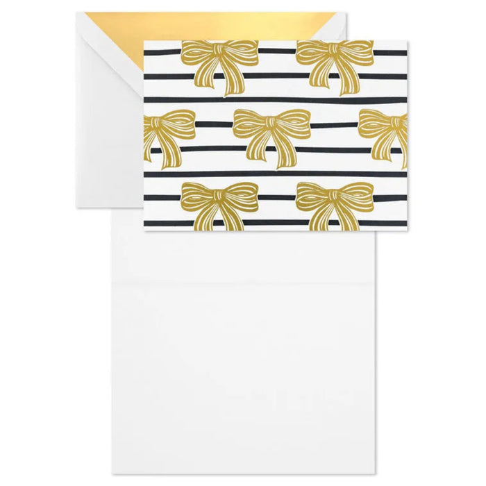 Note card with gold bow pattern on black and white striped background, accompanied by a matching envelope.