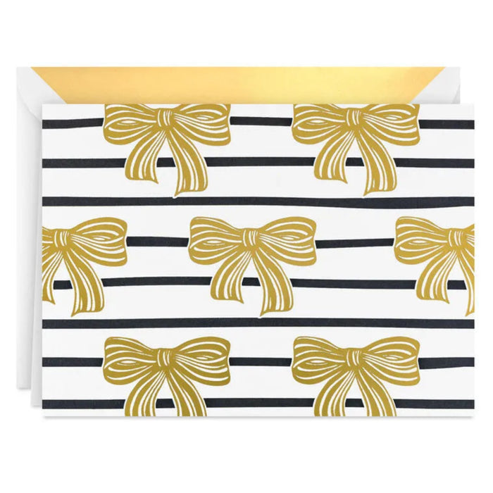 Card with gold bows on black and white striped pattern