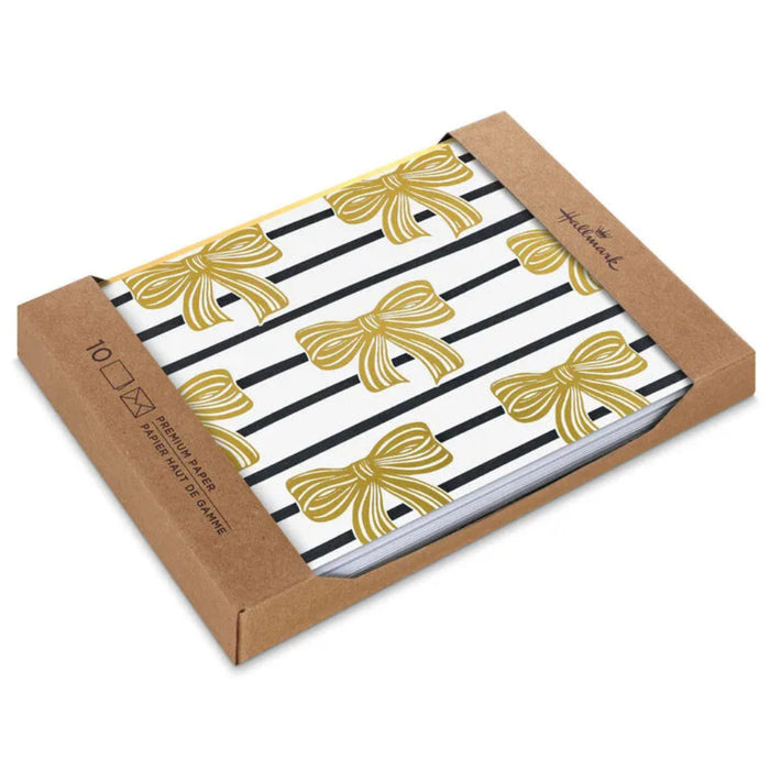 Pack of stationery with gold bows and black stripes on a white background