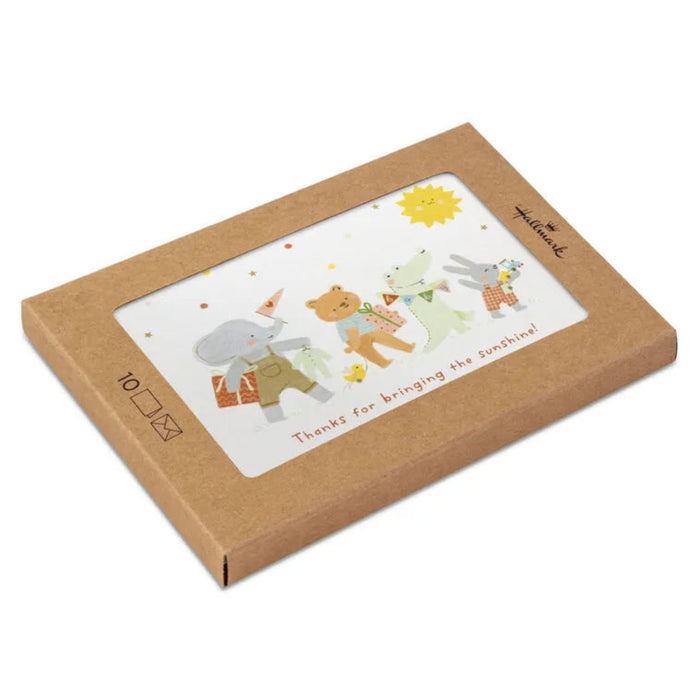 Card with cartoon animals and a sun, inside a brown cardboard box