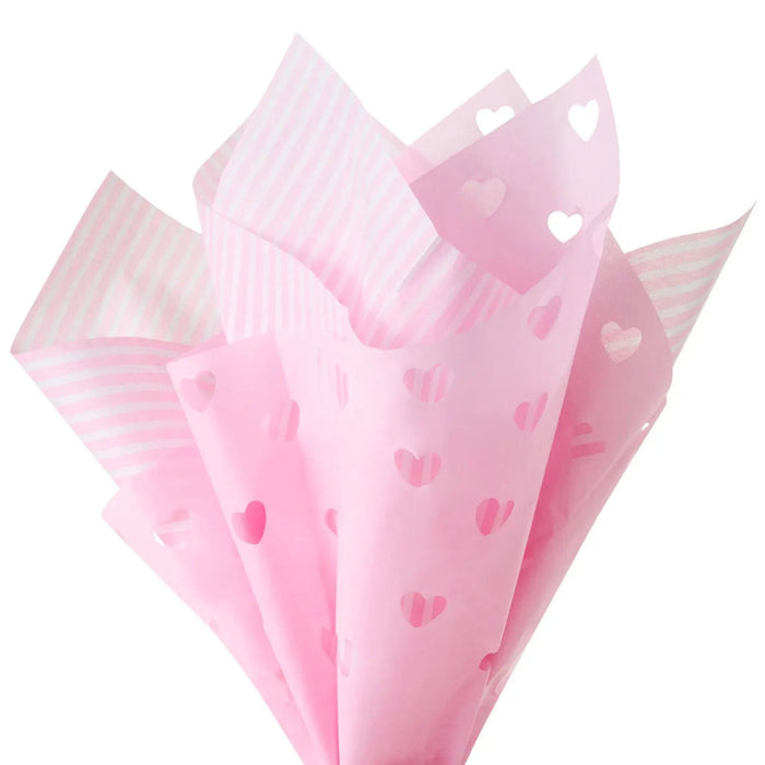Close‑up of pink tissue paper showing striped pattern and heart‑cutout design