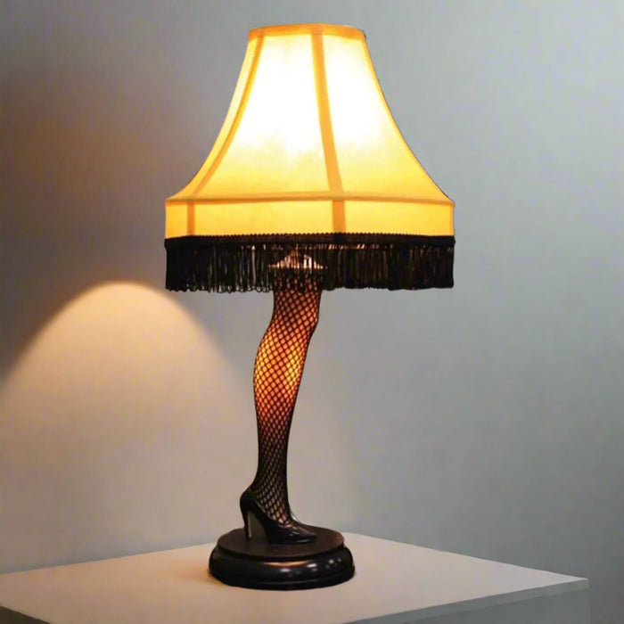 Classic 20-inch Leg Lamp from A Christmas Story featuring yellow shade and sculpted leg on a desk in a room 