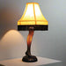 Classic 20-inch Leg Lamp from A Christmas Story featuring yellow shade and sculpted leg on a desk in a room 