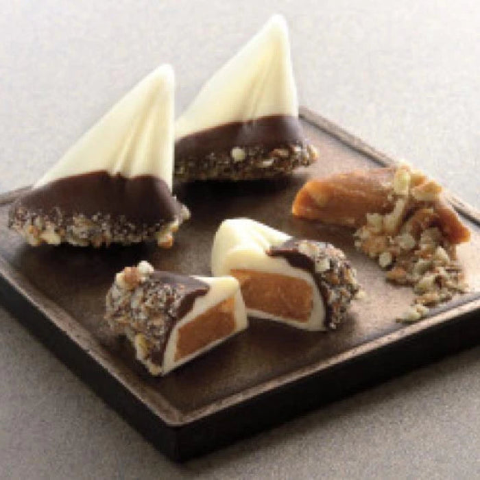 Sailboat shaped almond buttercrunch toffee covered with white chocolate and dipped in dark chocolate and pecan spindrift