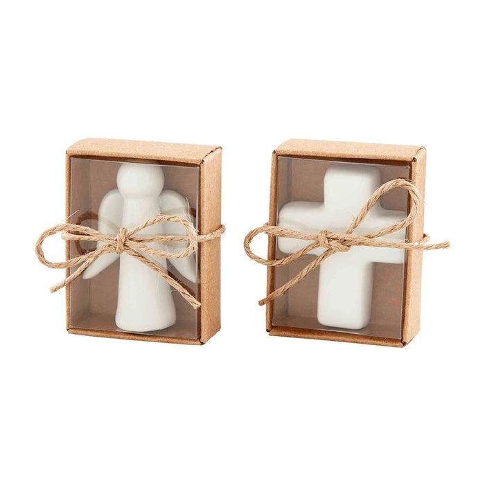 Two white candles placed in a box, topped with a cross, symbolizing faith and serenity.