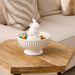A charming white ceramic bunny featuring vibrant polka dots, positioned upright and looking playful.