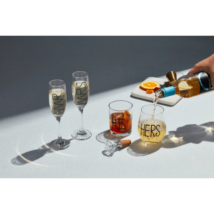  Two elegant champagne flutes, one marked "Mrs" and the other "Ws," set for a festive occasion.